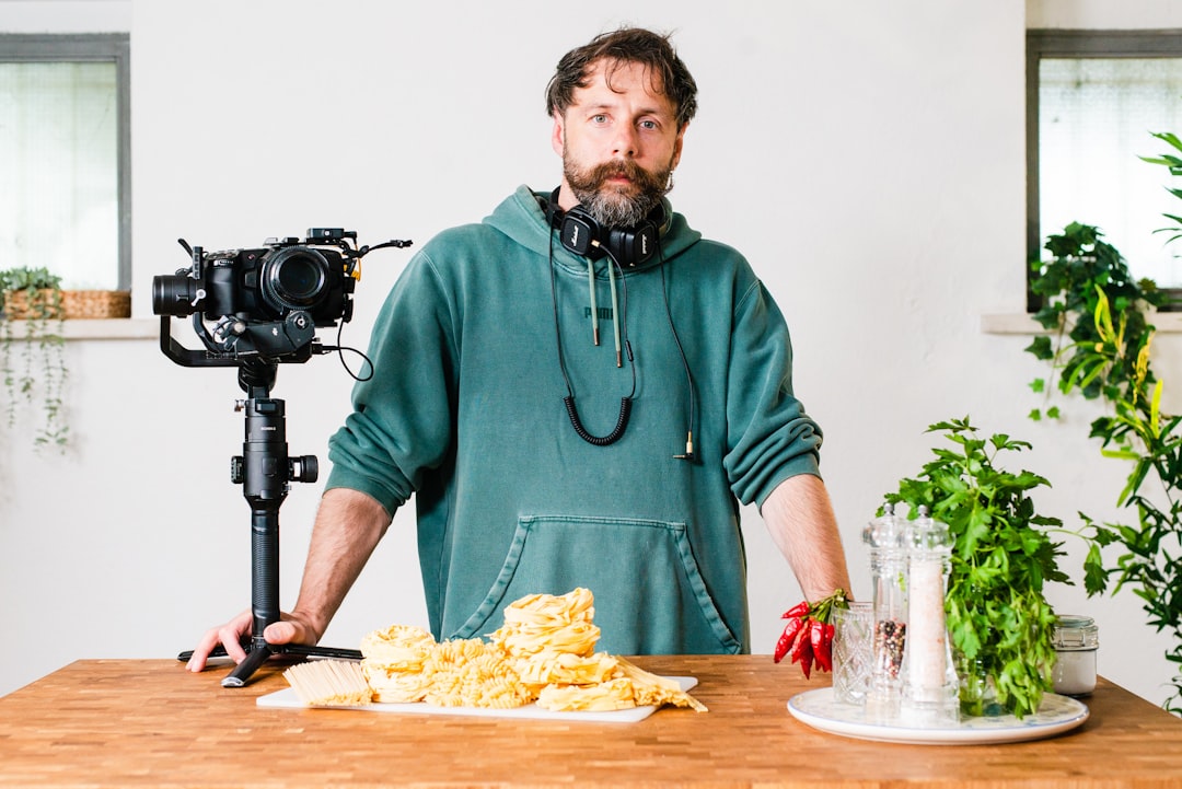 A cooking creator filming a plating sequence with natural lighting