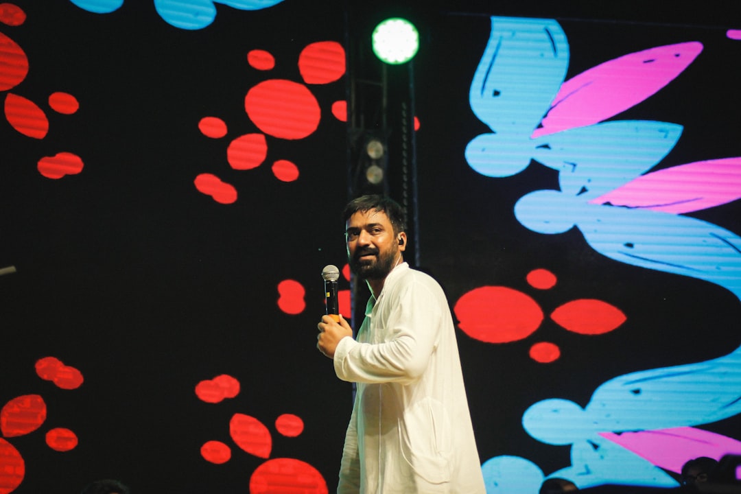 Speaker on stage with audience in the background, captured from a medium distance